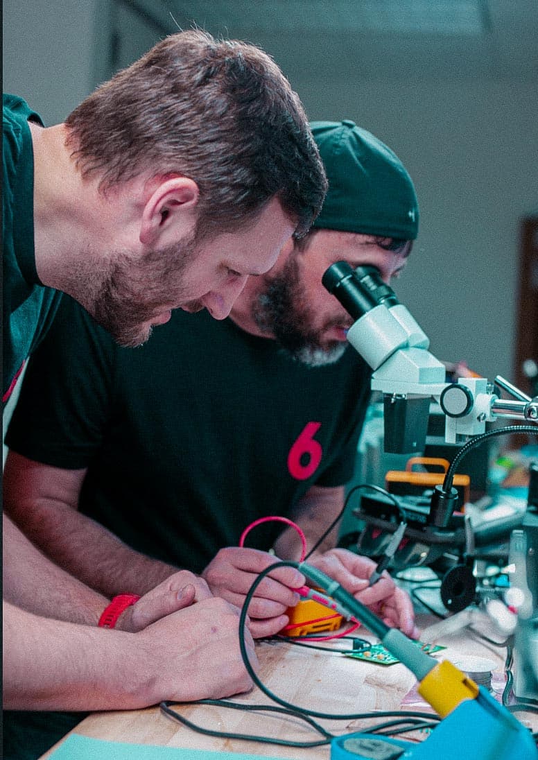 Red 6 engineers working on hardware at a lab bench
